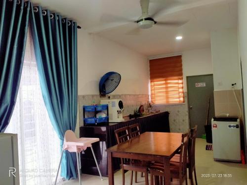 a kitchen and dining room with a table and blue curtains at Sri Manik Guest House Tanjung Karang in Tanjung Karang