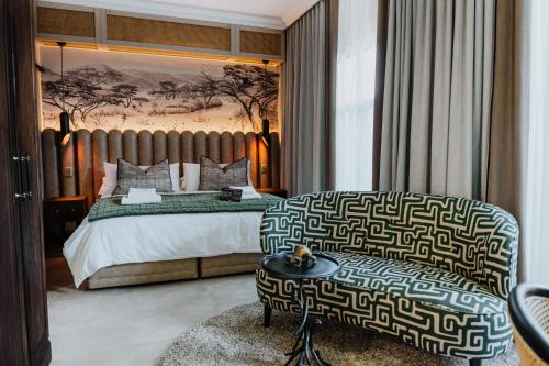- une chambre avec un grand lit et une chaise dans l'établissement Oryx Boutique Hotel, à Klerksdorp