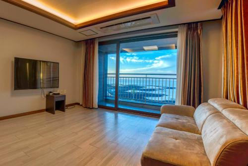 sala de estar con sofá y ventana grande en O2Heal resort en Jeju