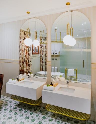 a bathroom with two sinks and two mirrors at Oryx Boutique Hotel in Klerksdorp