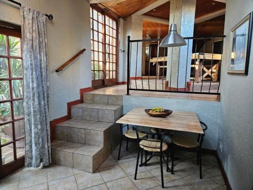 a dining room with a table and a staircase at Grobler's Haven Self catering cottage in Pretoria
