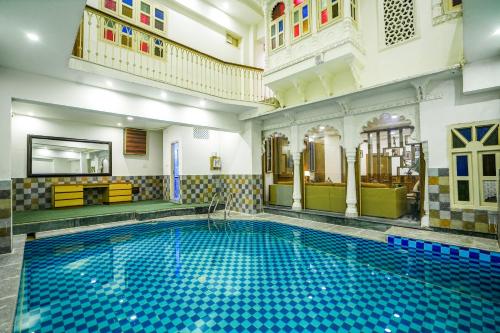 a large swimming pool in a building with a swimming pool at Royal Rafahiya Haveli - LAKE FACING in Udaipur