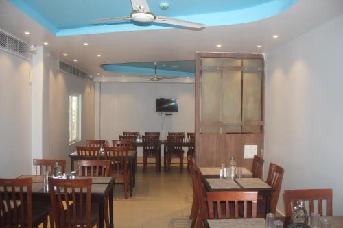 a dining room with tables and chairs and a ceiling at Hotel Serene Palace in Port Blair