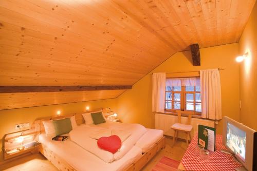 ein Schlafzimmer mit einem Bett mit einem roten Herz darauf in der Unterkunft Naze`s Hus Mellau in Mellau