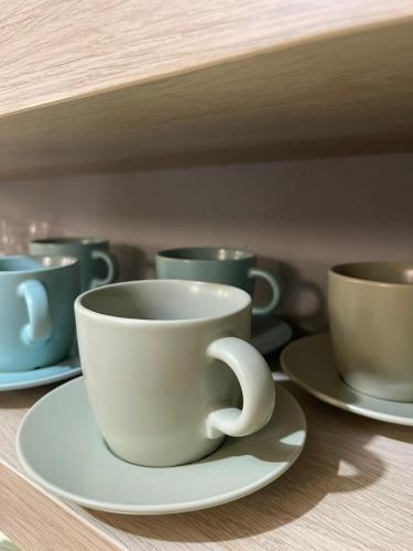 a cup on a plate on a shelf with other cups at Veľký apartman in Karlova Ves