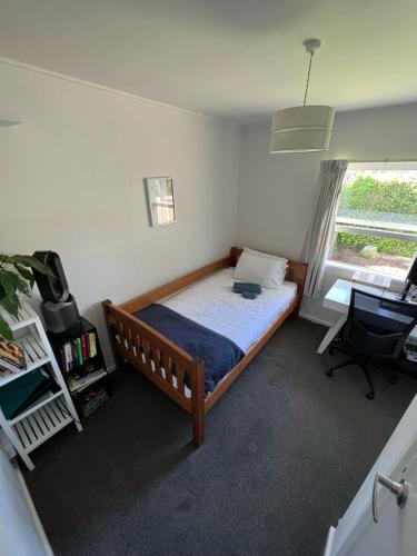 a bedroom with a bed and a desk and a window at Linden Lodge Haven in Wellington