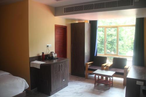 a bedroom with a bed and a desk and a window at Hotel Serene Palace in Port Blair