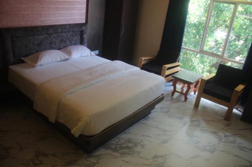 a bedroom with a large bed and a window at Hotel Serene Palace in Port Blair