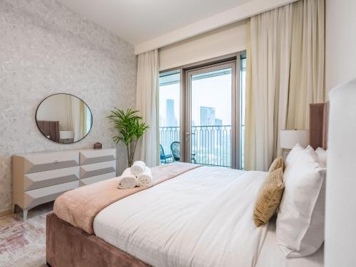 - une chambre avec un grand lit et une grande fenêtre dans l'établissement Phenomenal 2Br in Downtown Views II, à Dubaï