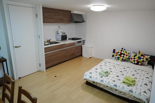 1 dormitorio pequeño con 1 cama y cocina en Orange House 702 en Osaka