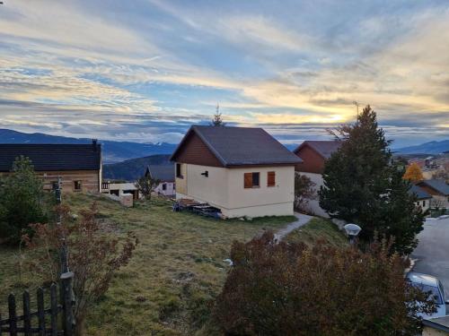 a small white house on a hill with mountains in the background at Petit chalet individuel à Font-romeu in Font-Romeu-Odeillo-Via