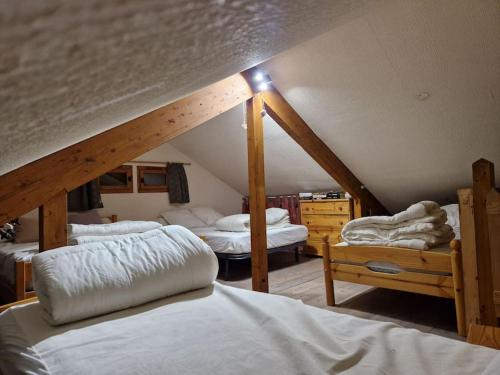 a attic room with three beds and a staircase at Petit chalet individuel à Font-romeu in Font-Romeu-Odeillo-Via