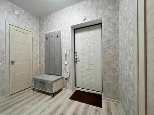 uma casa de banho com uma cabina de duche ao nível do chão e uma porta em Уютная и новая квартира в Костанае em Qostanay