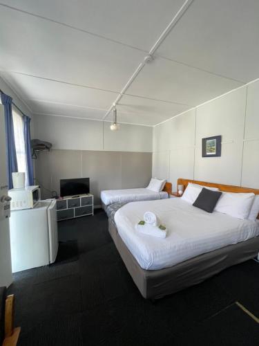 a hotel room with two beds and a television at Mountain View Motel in Queenstown