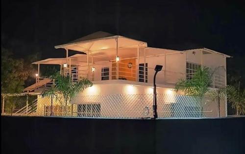 uma casa branca com uma cerca em frente à noite em SHER 3BHK VILLA ALIBAUG em Alibaug