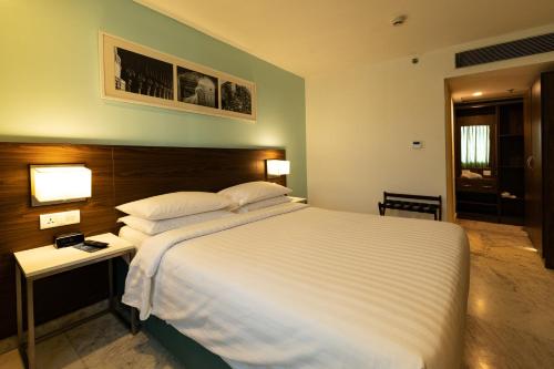 a bedroom with a large white bed and a table at Fairfield by Marriott Pune Kharadi in Pune