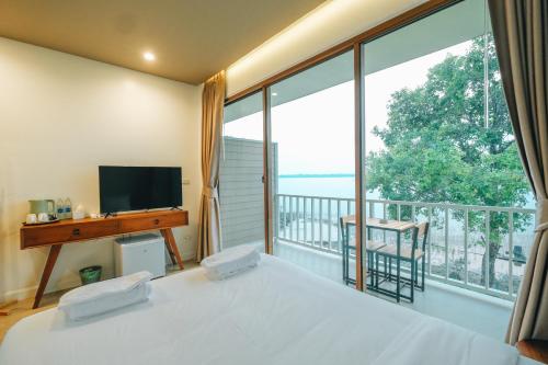 een slaapkamer met een bed en een groot raam bij LAKE HOUSE Naka Cave in Ban Don Klang