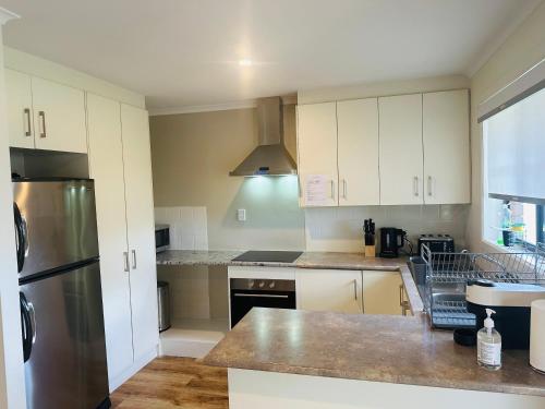 a kitchen with white cabinets and a stainless steel refrigerator at Kangaroo Island Homestays in Kingscote