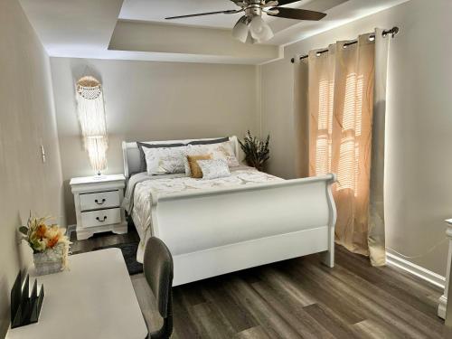 a white bedroom with a bed and a ceiling fan at DreamStay in Dacula
