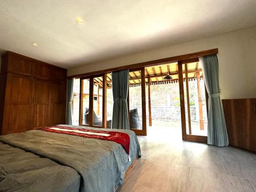 um quarto com uma cama e portas de vidro deslizantes em Gamelan Amed Villa em Amed