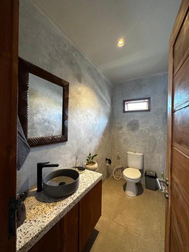 uma casa de banho com um lavatório e um WC em Gamelan Amed Villa em Amed