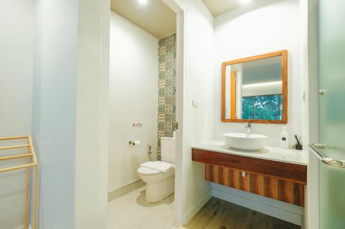 La salle de bains est pourvue d'un lavabo, de toilettes et d'un miroir. dans l'établissement LAKE HOUSE Naka Cave, à Ban Don Klang