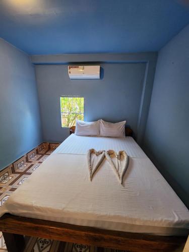 two hearts on a bed in a blue room at Sweet View Guesthouse in Koh Rong