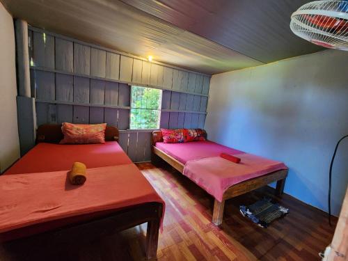 a small room with two beds and a table at Sweet View Guesthouse in Koh Rong