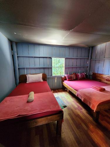 a room with two beds with red sheets and a window at Sweet View Guesthouse in Koh Rong