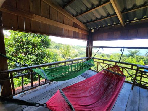 a hammock on a balcony with a view of the forest at Sweet View Guesthouse in Koh Rong