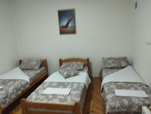 a room with three beds and a picture on the wall at Apartman Milicevic in Bileća