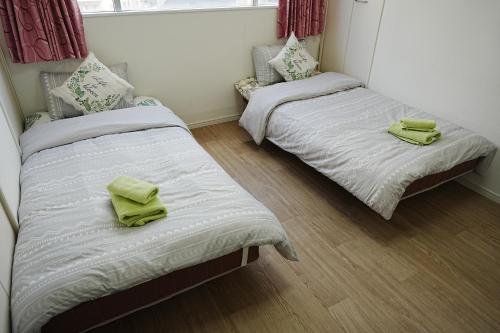 大阪市にあるOrange House 701のベッド2台(緑のタオル付)