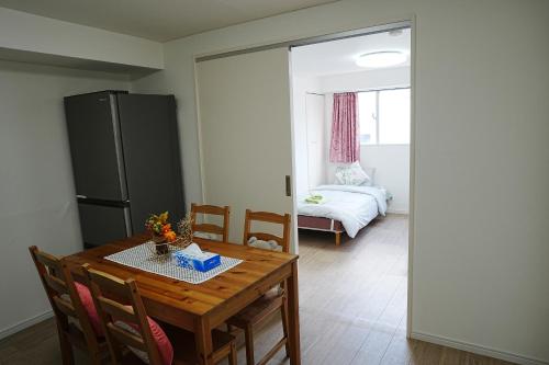 大阪市にあるOrange House 701のテーブルと冷蔵庫のあるダイニングルーム
