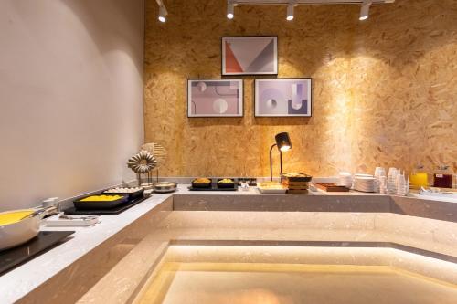 a kitchen with a large bath tub in a room at Platinum Century Hotel in Huizhou