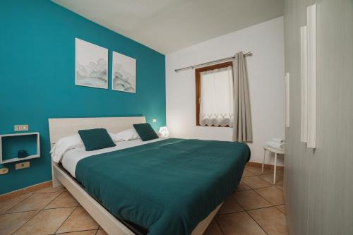 een slaapkamer met een groot bed met blauwe muren bij Maison Escaliers in Aosta