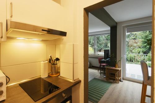 uma cozinha com fogão forno superior ao lado de uma sala de estar em Central apartment with Terrace em Duisburg
