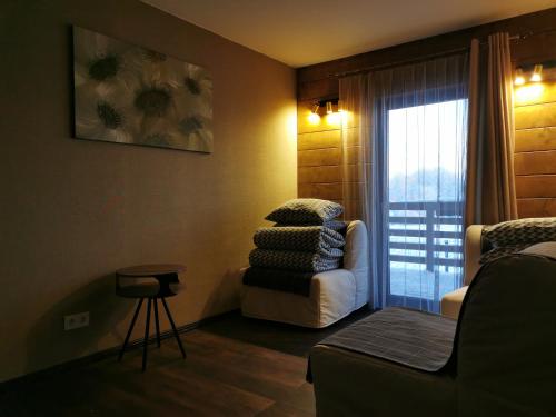 uma sala de estar com uma cadeira e uma janela em ''Ābeļdārzs'' em Jelgava