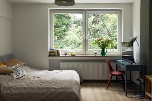 um quarto com uma cama, uma secretária e uma janela em Central apartment with Terrace em Duisburg