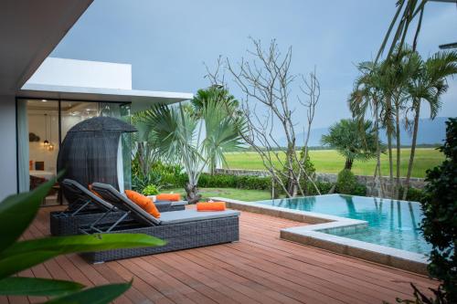 a deck with a pool and chairs next to a house at Wonderland Suites and Resort in Sihanoukville