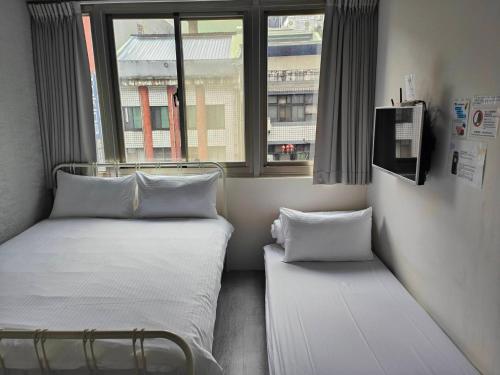 two beds in a small room with a window at 109台北旅館-台北109青旅 109 Taipei Hotel - Taipei 109 Hostel in Taipei