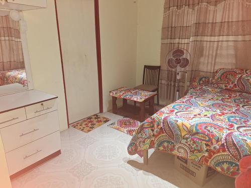 1 dormitorio con 1 cama, vestidor y silla en awesome stay en Nadi