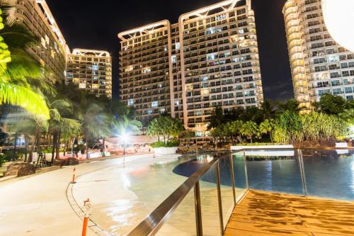 ein Pool in einer Stadt in der Nacht mit hohen Gebäuden in der Unterkunft Azure Urban Residence A11 Near Airport and SM Bicutan+ Free wifi in Manila