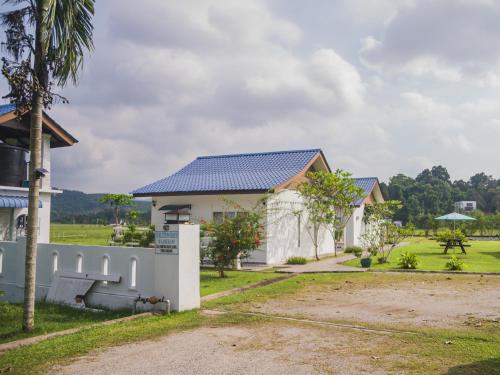 uma casa com um telhado azul em Halcyon Days @ Langkawi em Pantai Cenang