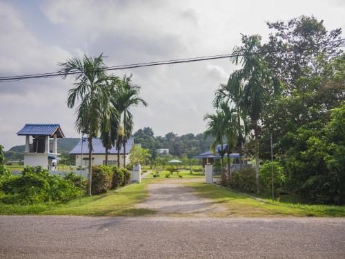 a road leading to a house with palm trees at Halcyon Days @ Langkawi in Pantai Cenang