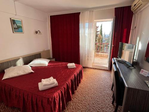 een hotelkamer met een rood bed en een raam bij Hotel Flora in Drobeta-Turnu Severin