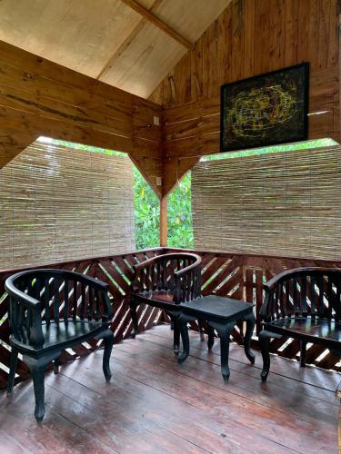 Pipulu的住宿－Byeropa Resort & Resto，门廊,上面有三张长椅和一张桌子