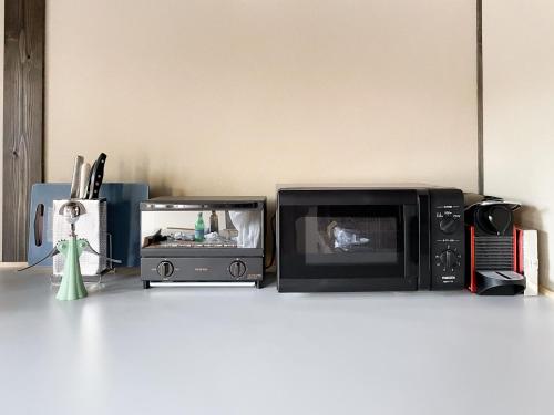 a microwave and a toaster oven on a counter at Akizuki Kayabuki Kominka in Asakura