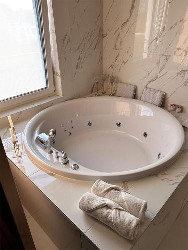a large white bath tub in a bathroom at Secret Place apartments, luxury and spa in Zdenci Brdovečki