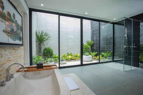ein Bad mit einer Dusche und einem großen Fenster in der Unterkunft Wonderland Suites and Resort in Sihanoukville
