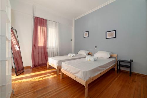 a bedroom with two beds and a wooden floor at Spacious 2bd apartment next to Athens Archeological museum in Athens